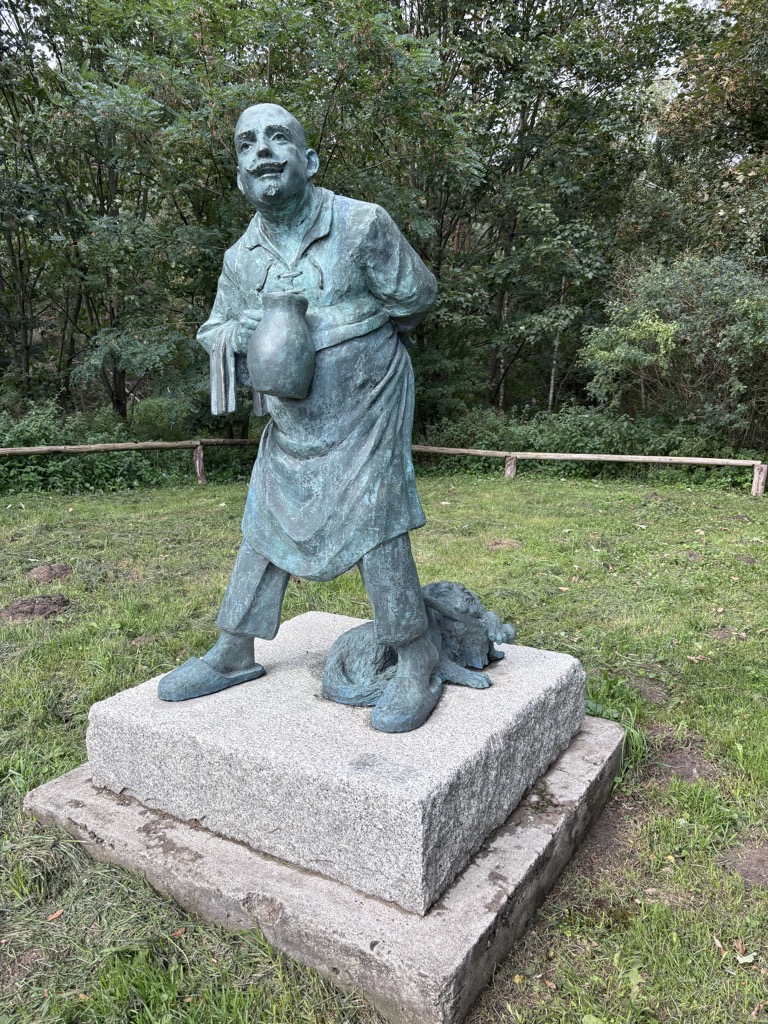 Zbliżenie pomnika Karczmarza z Waliszewa na tle lasu